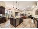 Open concept kitchen with island, stainless appliances, and views into the adjacent living space with fireplace at 19717 E Country Meadows Dr, Queen Creek, AZ 85142