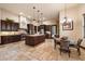 Chef's kitchen features stone floors, center island, granite counters, custom cabinets, and stainless appliances at 19717 E Country Meadows Dr, Queen Creek, AZ 85142