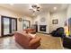 Cozy living room featuring a fireplace, comfortable seating, and views of the outdoor space at 19717 E Country Meadows Dr, Queen Creek, AZ 85142