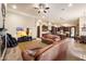 Open-concept living room with stone floors, a fireplace, and access to a chef's kitchen at 19717 E Country Meadows Dr, Queen Creek, AZ 85142