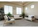 Comfortable living area with neutral colors, white couches, and large windows for natural light at 19717 E Country Meadows Dr, Queen Creek, AZ 85142