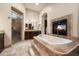 Luxurious main bathroom boasting a jacuzzi tub, walk-in shower, and a cozy fireplace at 19717 E Country Meadows Dr, Queen Creek, AZ 85142