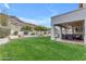 Expansive backyard features lush green lawn, covered patio, and desert landscaping, perfect for outdoor enjoyment at 2008 E Rock Wren Rd, Phoenix, AZ 85048