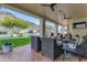 Covered patio with comfortable seating, ceiling fans, and landscaped backyard view at 2008 E Rock Wren Rd, Phoenix, AZ 85048