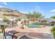 Outdoor pool area with lounging chairs, rock features, and desert landscaping at 2008 E Rock Wren Rd, Phoenix, AZ 85048