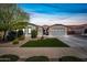 Beautiful home with a lush green lawn, mature landscaping, and a two-car garage, creating curb appeal at 22372 E Duncan St, Queen Creek, AZ 85142