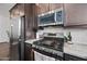 Close up view of kitchen with stainless steel appliances including gas range and microwave at 22372 E Duncan St, Queen Creek, AZ 85142