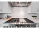 Close-up of a high-end stainless steel range with white subway tile backsplash in the modern kitchen at 22372 E Duncan St, Queen Creek, AZ 85142
