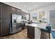 Stylish kitchen with dark cabinetry, stainless appliances, and a convenient breakfast bar at 22372 E Duncan St, Queen Creek, AZ 85142