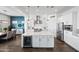 Open-concept kitchen featuring a large island with seating, stainless steel appliances, and modern lighting fixtures at 22372 E Duncan St, Queen Creek, AZ 85142