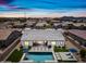 Aerial view of a backyard pool with lounge chairs, turf, and desert landscaping under a vibrant sunset sky at 22372 E Duncan St, Queen Creek, AZ 85142