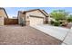 A view of the home's exterior, featuring a two-car garage and low-maintenance desert landscaping at 2336 W Magdalena Ln, Phoenix, AZ 85041