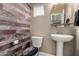 Bathroom featuring a pedestal sink, toilet, and wood accent wall at 240 W Juniper Ave # 1053, Gilbert, AZ 85233