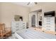 Bright bedroom featuring two dressers, a chair, and an open doorway to a bathroom at 240 W Juniper Ave # 1053, Gilbert, AZ 85233