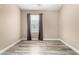 A bedroom with light-colored walls, light wood floors, and a window with grey curtains at 240 W Juniper Ave # 1053, Gilbert, AZ 85233