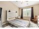 Bright bedroom with a ceiling fan, window, and furnished with a bed frame and rocking chair at 240 W Juniper Ave # 1053, Gilbert, AZ 85233