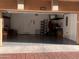 Open garage with storage shelves, door to inside, and grey-coated floor at 240 W Juniper Ave # 1053, Gilbert, AZ 85233