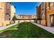Exterior view showcasing manicured green spaces between residential buildings at 240 W Juniper Ave # 1053, Gilbert, AZ 85233