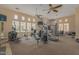 Bright community gym with a variety of machines, including ellipticals, stationary bikes, and weight lifting equipment at 240 W Juniper Ave # 1053, Gilbert, AZ 85233