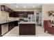 Modern kitchen featuring dark cabinets, granite countertops, stainless steel appliances, and a kitchen island at 240 W Juniper Ave # 1053, Gilbert, AZ 85233