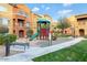 Community playground surrounded by green grass and landscaping at 240 W Juniper Ave # 1053, Gilbert, AZ 85233