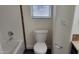 Clean bathroom with a white toilet, bath tub, and accent tile detail at 2460 E Main St # F7, Mesa, AZ 85213