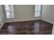 Empty bedroom with hardwood floors and large windows providing natural light at 2460 E Main St # F7, Mesa, AZ 85213