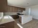 Bright kitchen featuring a large island, stainless steel appliances, dark cabinetry, and light countertops at 25215 W Wayland Dr, Buckeye, AZ 85326