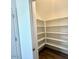 Walk-in pantry with lots of shelving for storage and laminate flooring at 25215 W Wayland Dr, Buckeye, AZ 85326