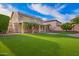 This property features a large backyard with artificial grass, a covered patio, and solar panels on the roof at 25425 N 64Th Ave, Phoenix, AZ 85083