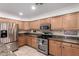 Cozy kitchen showcasing modern stainless steel appliances and custom oak cabinetry at 25425 N 64Th Ave, Phoenix, AZ 85083