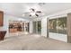 Open-plan living room with ceiling fan and sliding glass doors to outdoor patio and yard at 25425 N 64Th Ave, Phoenix, AZ 85083