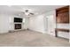 Comfortable living room features a fireplace, ceiling fan, and built-in wood cabinet at 25425 N 64Th Ave, Phoenix, AZ 85083