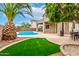 Manicured lawn with pool, covered patio and desert plants at 25695 W Crown King Rd, Buckeye, AZ 85326