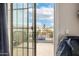 A balcony showcasing outdoor living with a glimpse of the neighborhood through a sliding glass door at 25695 W Crown King Rd, Buckeye, AZ 85326