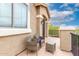 Cozy balcony with wicker seating, glass table, and stucco wall at 25695 W Crown King Rd, Buckeye, AZ 85326