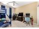 This bedroom features a ceiling fan, a blue bunk bed, and two computer desk stations for work and play at 25695 W Crown King Rd, Buckeye, AZ 85326