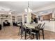 Dining area adjacent to the kitchen featuring modern black chairs, overhead lighting, and ceramic tile flooring at 25695 W Crown King Rd, Buckeye, AZ 85326