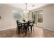 Dining area featuring modern black chairs, overhead lighting, ceramic tile flooring, and backyard access at 25695 W Crown King Rd, Buckeye, AZ 85326