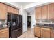 Kitchen showcases wood cabinets, mosaic backsplash, stainless refrigerator and convenient access to the laundry area at 25695 W Crown King Rd, Buckeye, AZ 85326