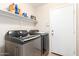 Well-equipped laundry room with modern side-by-side washer and dryer units for convenient chores at 25695 W Crown King Rd, Buckeye, AZ 85326