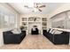 Comfortable living room with decorative shelving, ceiling fan, and two black sofas with patterned pillows at 25695 W Crown King Rd, Buckeye, AZ 85326