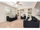 Comfortable living room with decorative shelving, ceiling fan, and two black sofas with patterned pillows at 25695 W Crown King Rd, Buckeye, AZ 85326