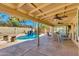 Covered backyard patio area with ceiling fans, a pool and waterfall feature at 302 E Carol Ann Way, Phoenix, AZ 85022