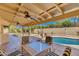 Covered backyard patio area with ceiling fans, a pool, and a landscaped yard at 302 E Carol Ann Way, Phoenix, AZ 85022