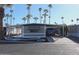 This home's exterior features a carport, desert landscaping, and mature palm trees at 303 S Recker Rd # 62, Mesa, AZ 85206