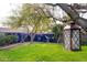 Large grassy backyard with a mural wall, mature trees, and privacy at 4945 E Shapinsay Dr, San Tan Valley, AZ 85140