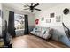 Cozy bedroom with wood floors, a gray futon, and a window with natural light at 4945 E Shapinsay Dr, San Tan Valley, AZ 85140