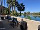 Inviting outdoor seating area with waterfront views and mature palm trees, perfect for relaxing and entertaining guests at 5110 N 31St Way # 345, Phoenix, AZ 85016