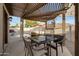 Inviting outdoor dining area under a pergola, offering a relaxing view of the sparkling pool at 5431 W Cochise Dr, Glendale, AZ 85302